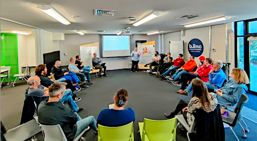 NeSI and AgResearch team sitting in a semi-circle in a room.